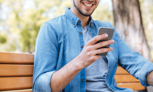 cropped-image-of-a-smiling-man-with-smartphone-sit-PHA6U4F_optimiert